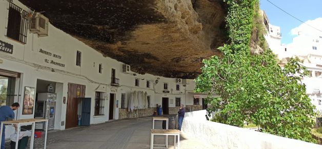 Casas y calle bajo la roca.
