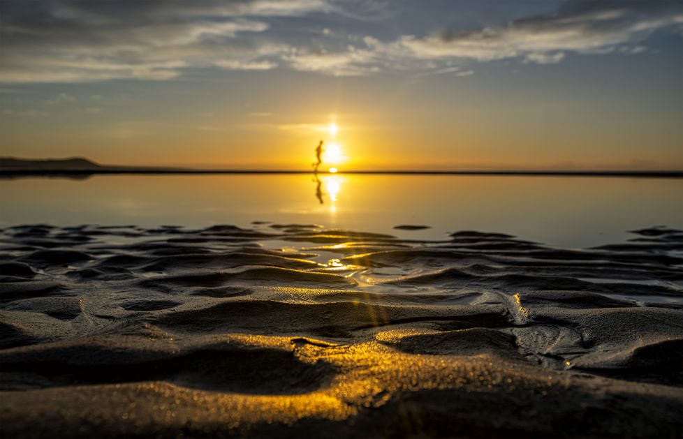 Haciendo deporte en la playa al atardecer.