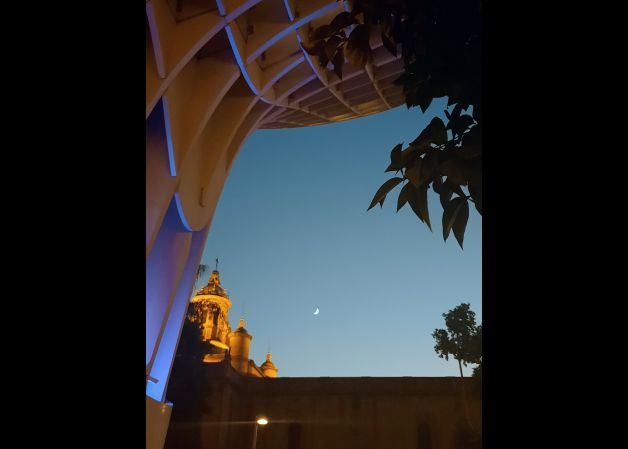 La luna entre estructuras modernas y antiguas.