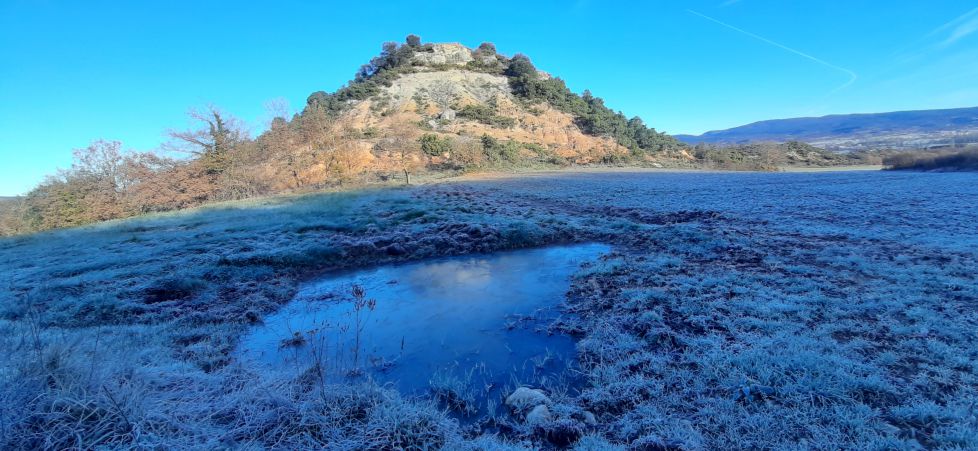 Laguna helada bajo un Sol radiante.